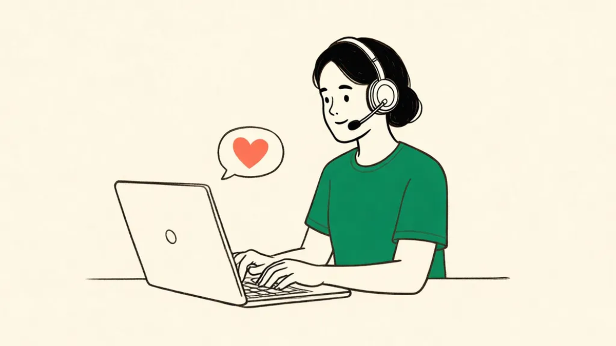 A volunteer wearing a headset types at a laptop, with a small heart in a speech bubble.